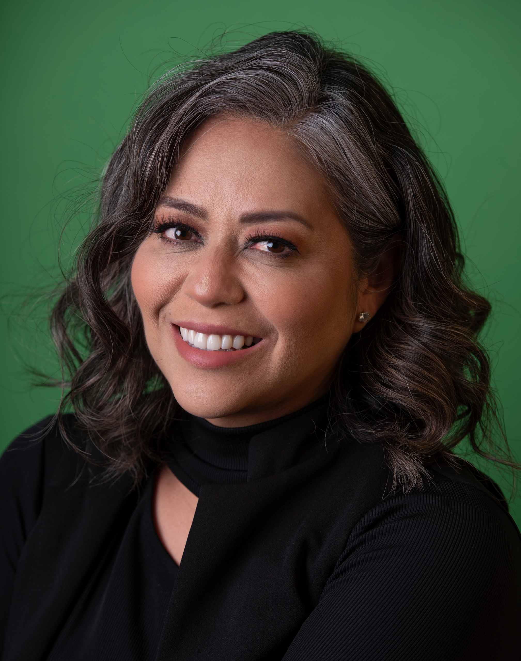 Headshot of Veronica Vasquez with a green background